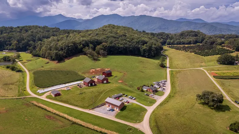 Farmland and red barns in a green East Tennessee valley below the mountains
