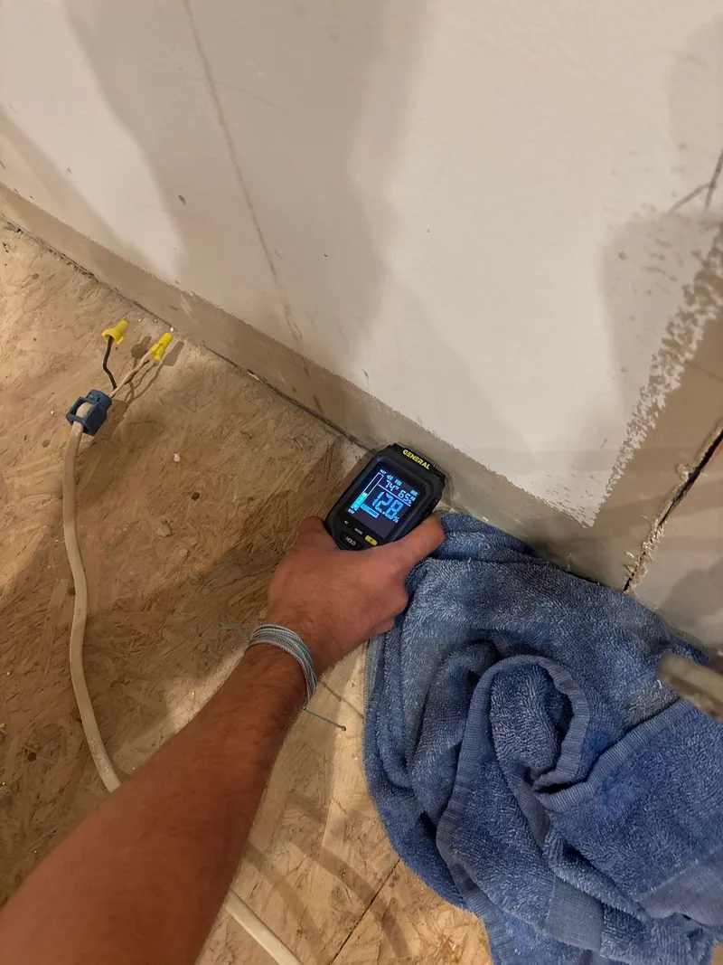 A moisture meter reading taken against an affected wall