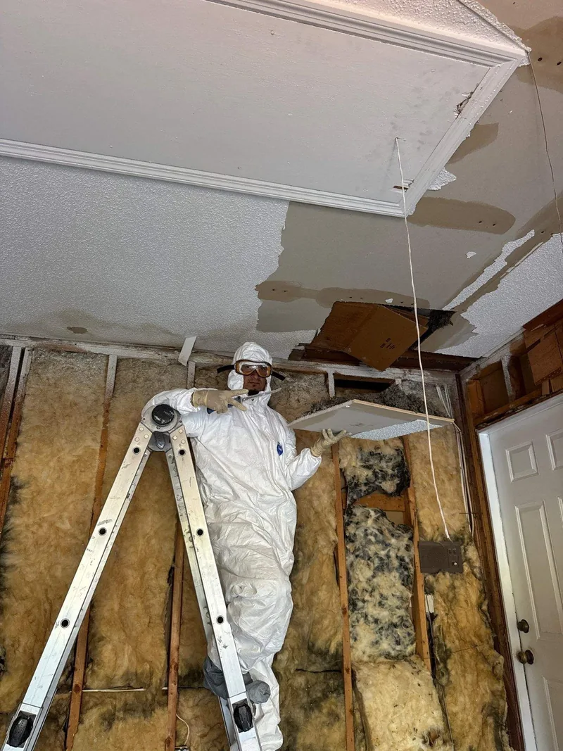 A technician working a ceiling in protective equipment